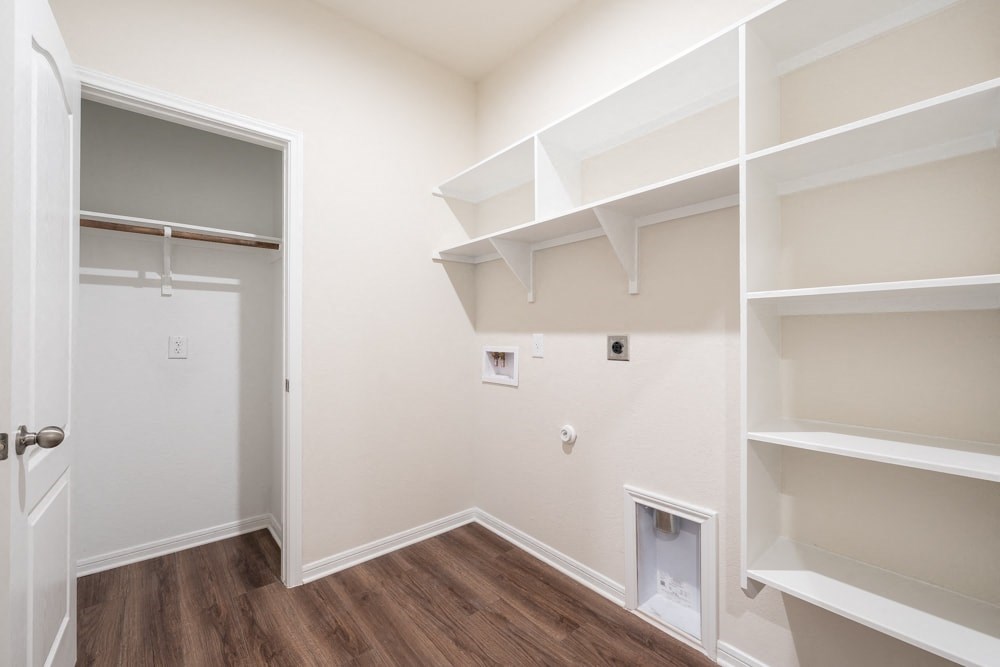a room with white shelves and a closet and a door
