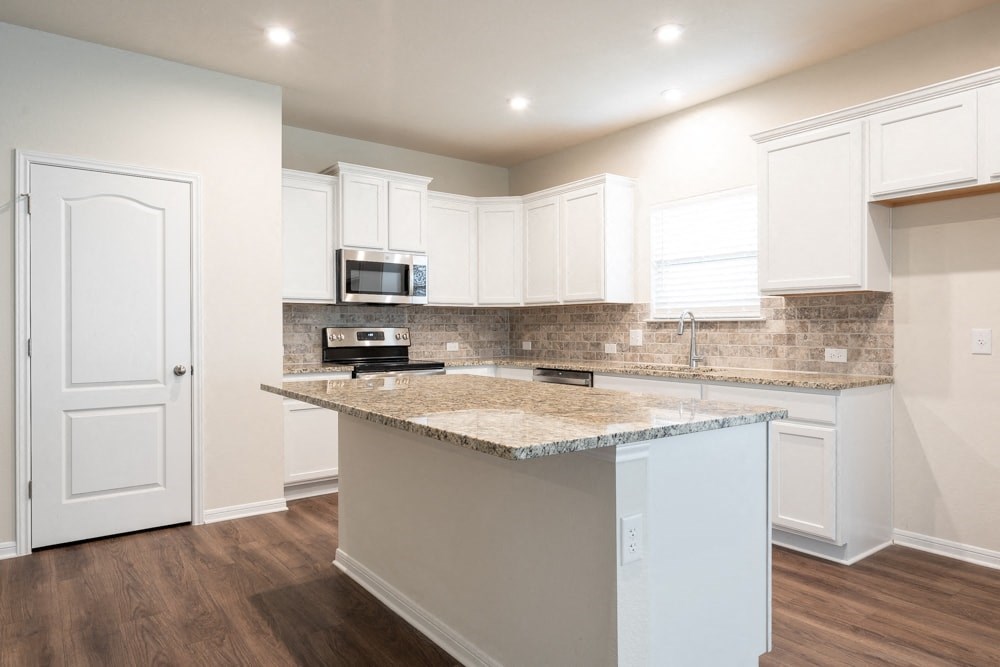 a kitchen with white cabinets and a counter top