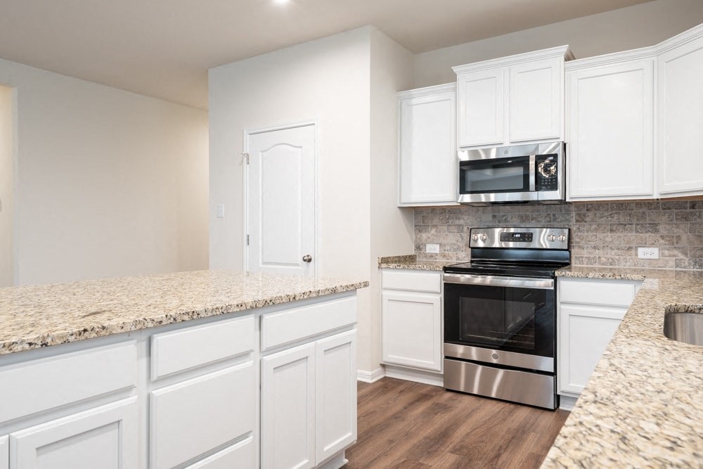 a kitchen with white cabinets and a counter top