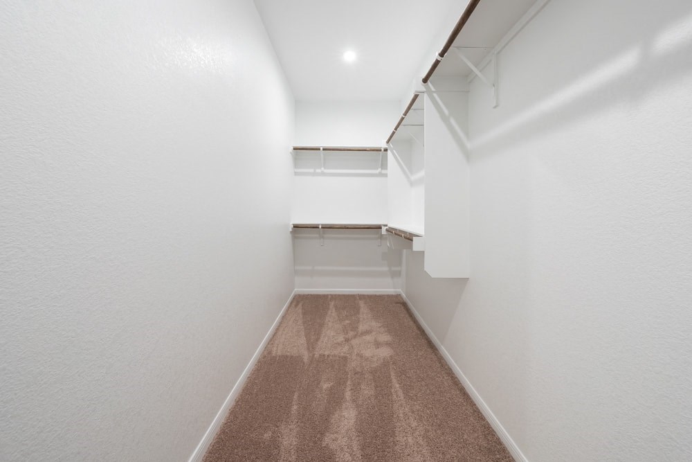 a room with white walls and a brown floor and a closet