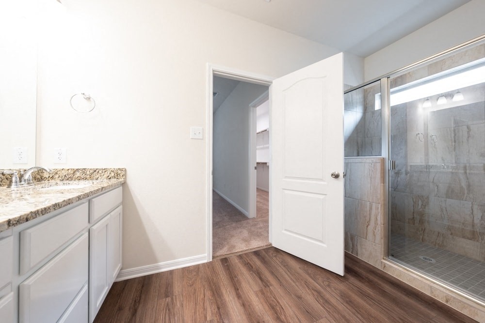 a bathroom with a shower and a sink and a mirror