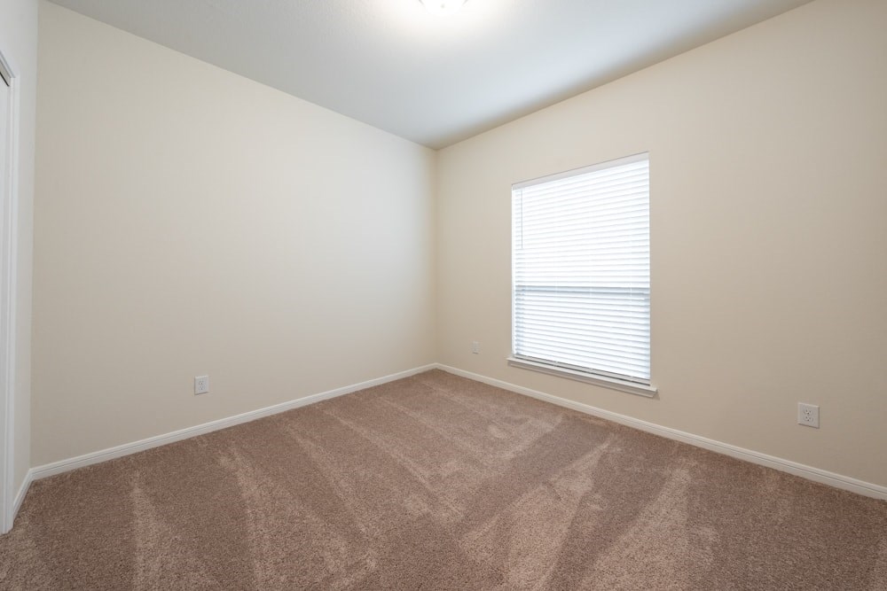 an empty room with carpet and a window