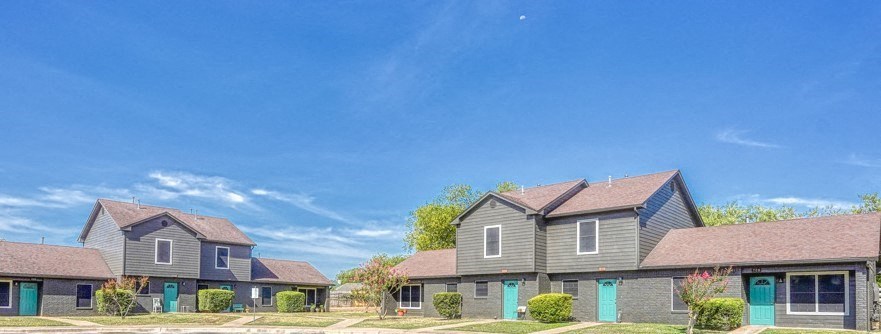 a row of houses with blue doors and a blue sky