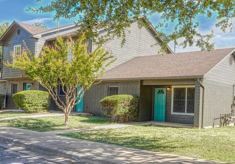 a white house with a blue door and a lawn