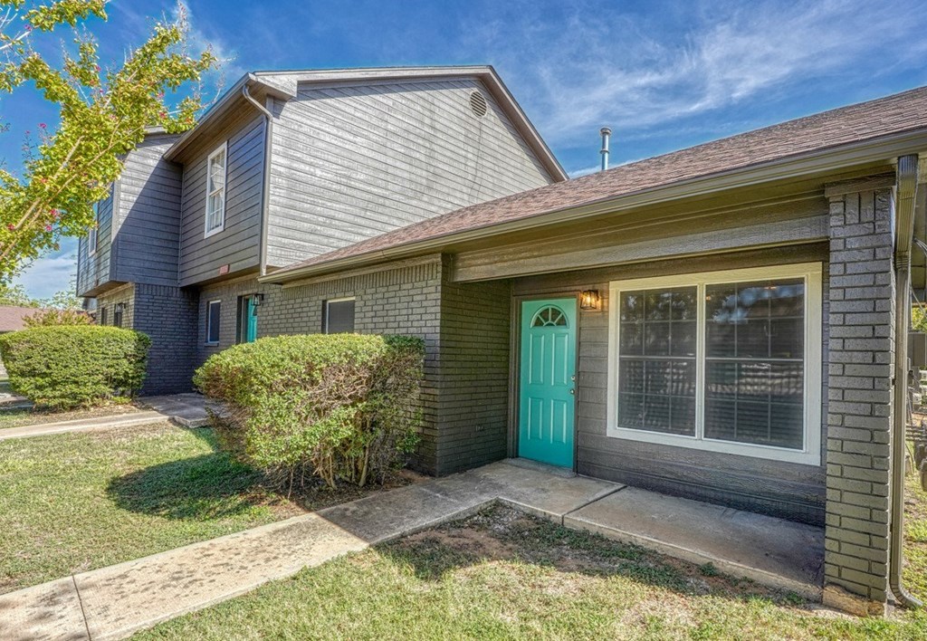 the front of a house with a blue door and a green door