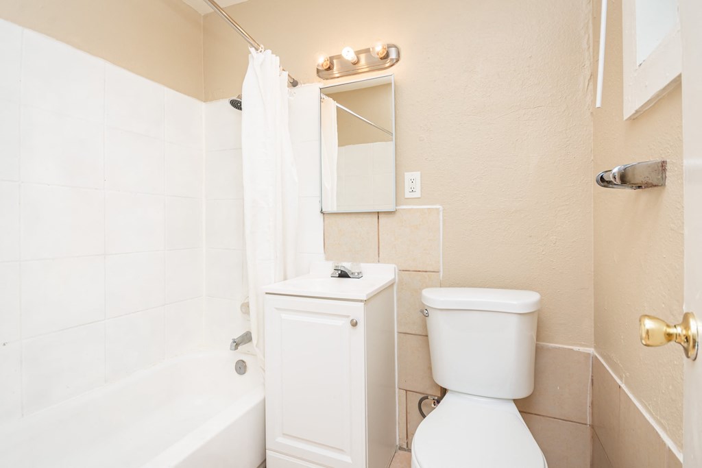 a bathroom with a white toilet and a shower