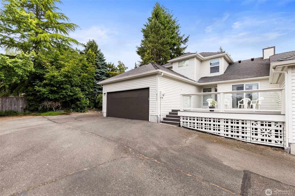 A house with a garage and a driveway in front of it.