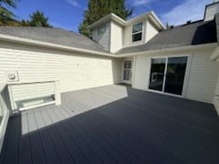 A white house with a grey roof and a grey deck.