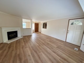 A room with a fireplace and wood flooring.