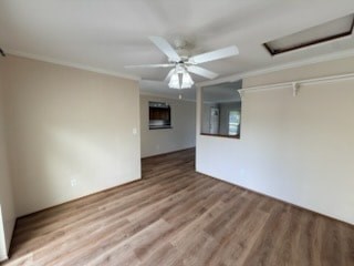 A room with a ceiling fan and wooden flooring.