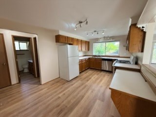A kitchen with wooden floors and white appliances.
