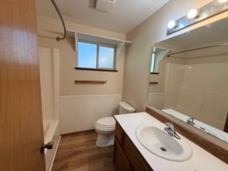 A small bathroom with a toilet, sink, and mirror.