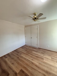 A room with a ceiling fan and a white door.