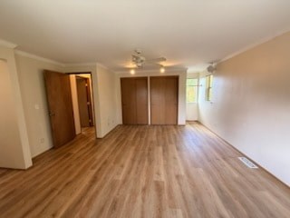 A room with wooden floors and two doors.