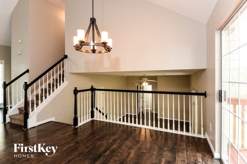 A well-lit foyer with a staircase and a chandelier.