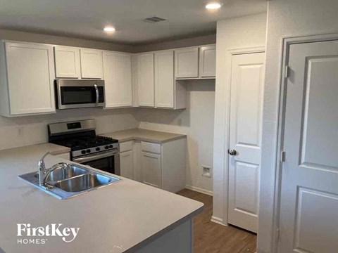 A kitchen with white cabinets and a stainless steel sink.