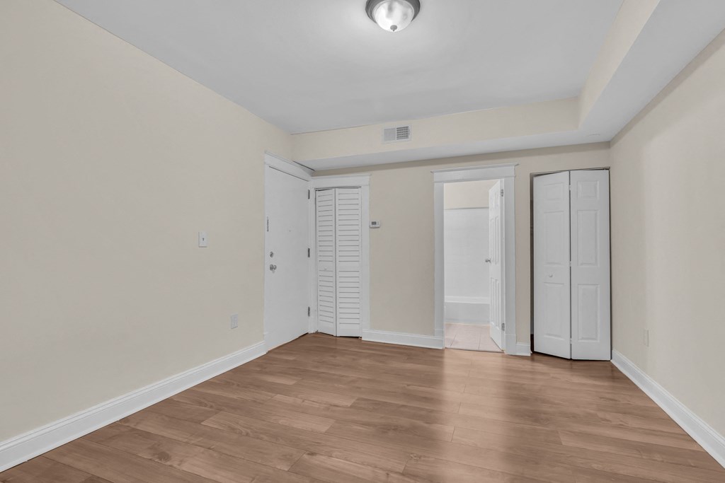 an empty living room with white walls and wood flooring