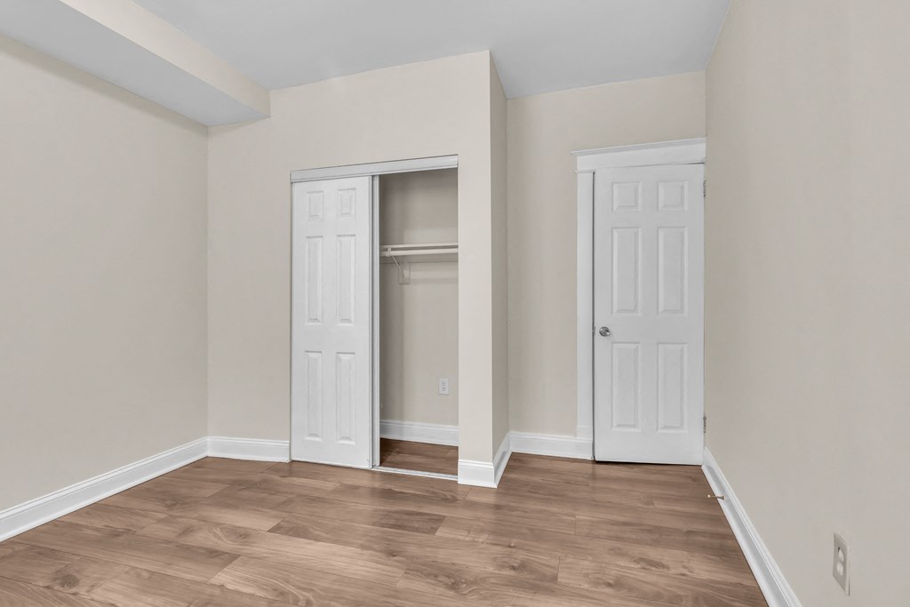 an empty room with two doors and a closet