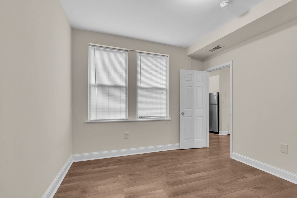 an empty living room with a door to a closet and a window