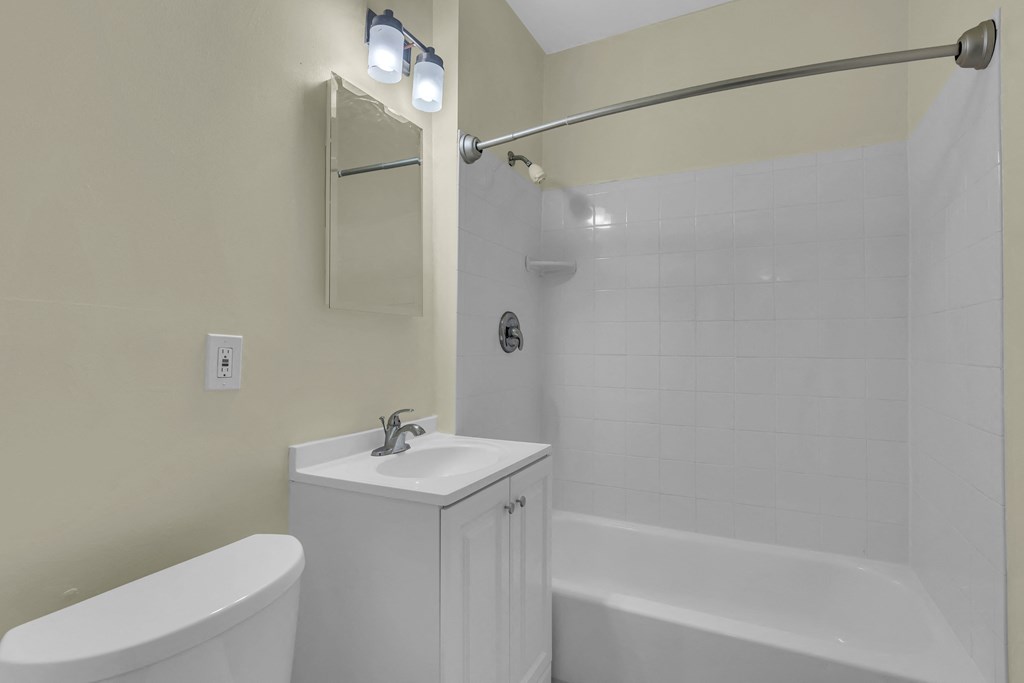 a white bathroom with a sink and a tub and a shower