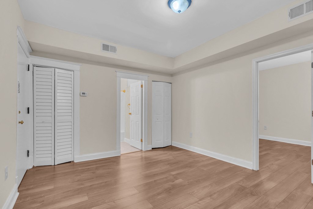 the living room of a new home with white walls and wood flooring