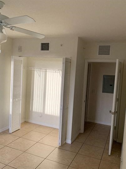 an empty room with a ceiling fan and a door
