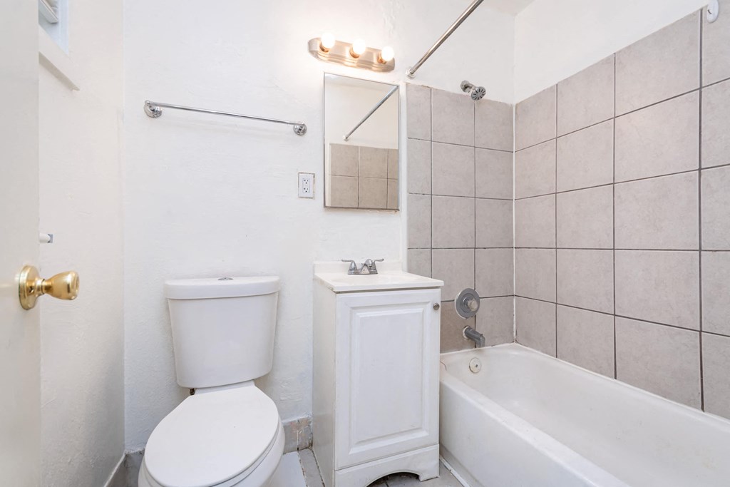 a bathroom with a toilet and a tub and a sink