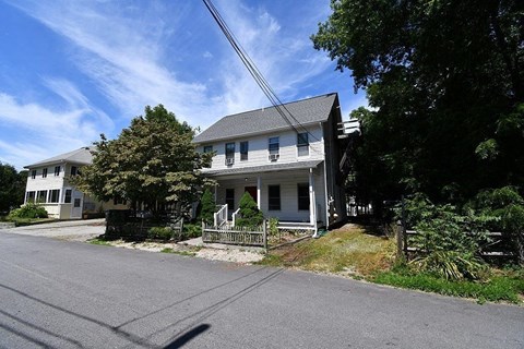 a white house sitting on the corner of a street