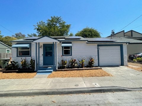 A small house with a blue door and white walls.
