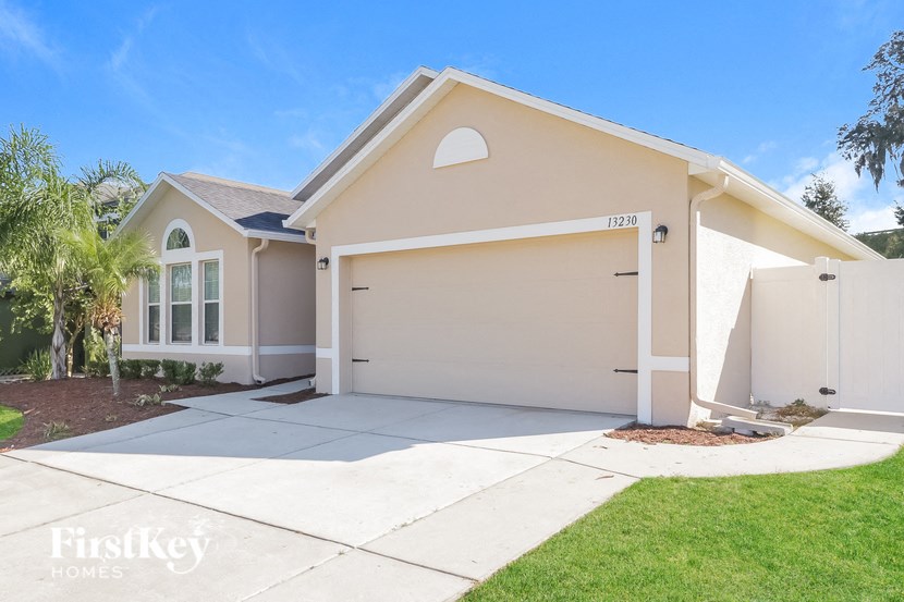 a beige house with a garage and a driveway