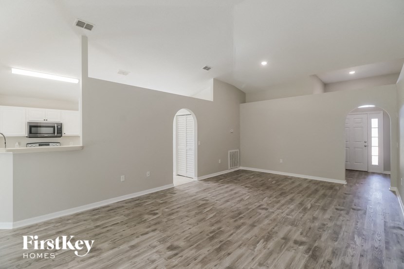 the living room and kitchen of a new home with wood flooring