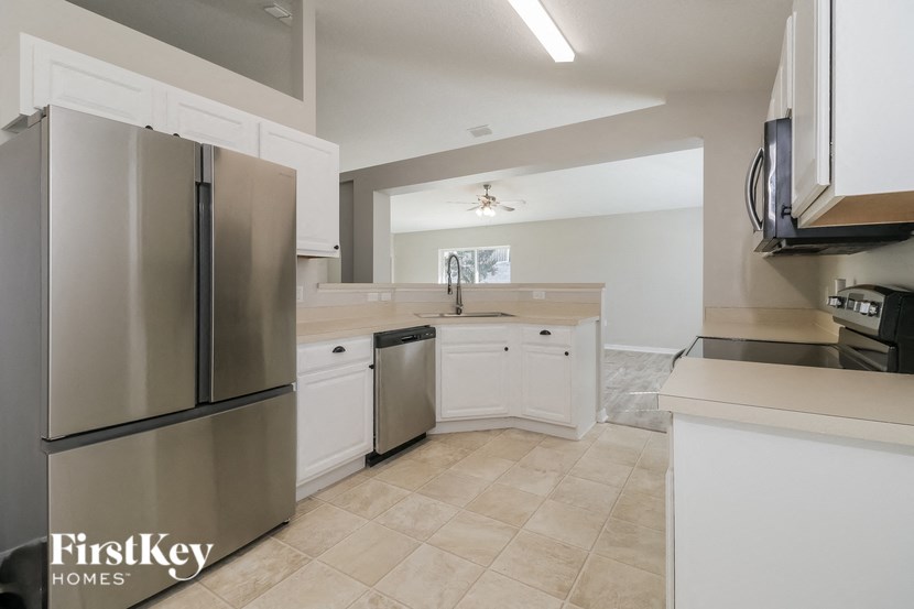a kitchen with white cabinets and a stainless steel refrigerator