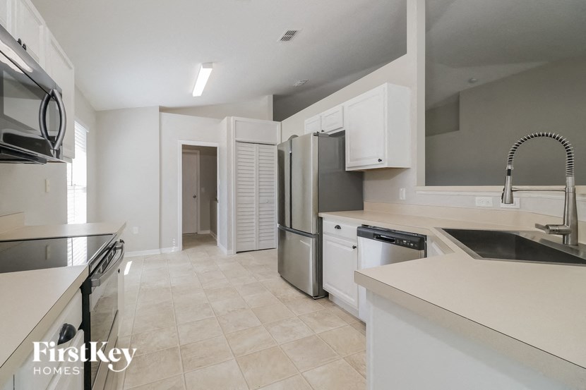 an empty kitchen with a sink and a refrigerator