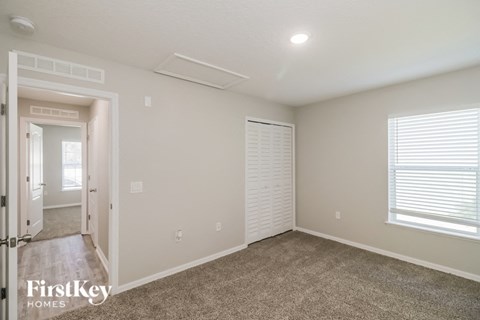 the living room of a home with carpet and a large window