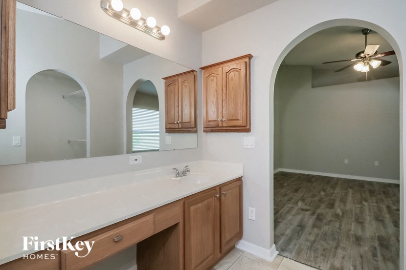 an empty bathroom with a large mirror and a sink