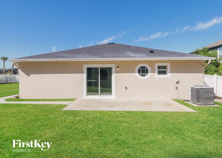a beige house with a yard and grass
