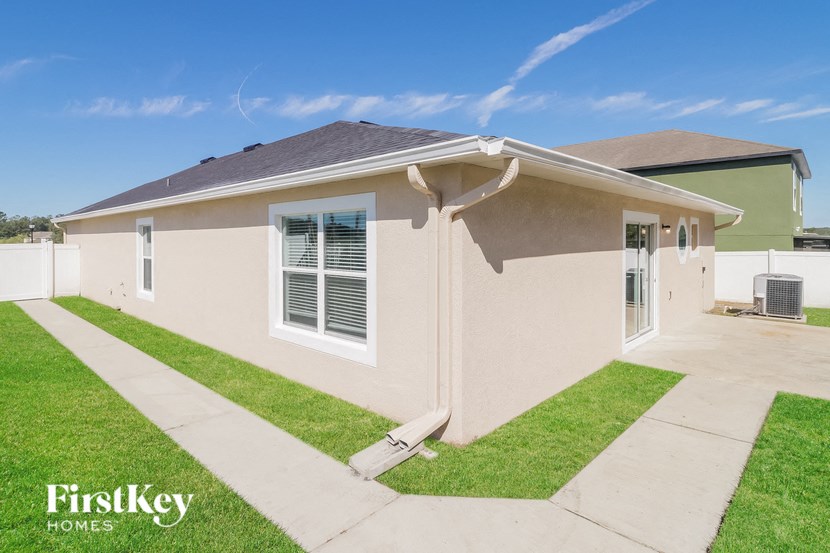 a beige house with a driveway and grass