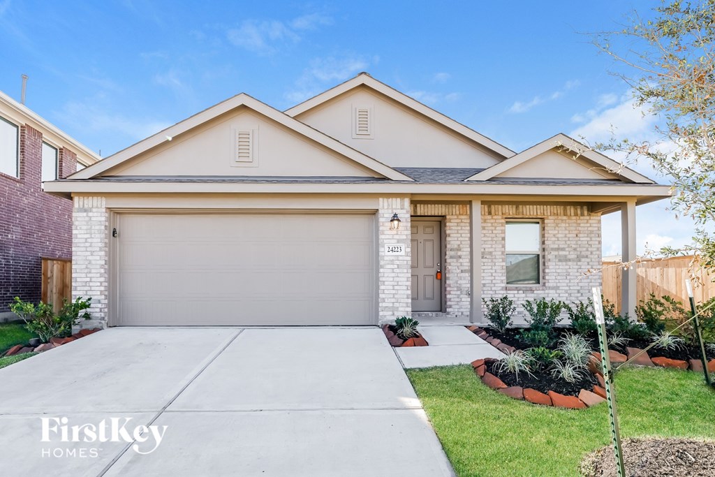 A house with a garage and a driveway in front of it.