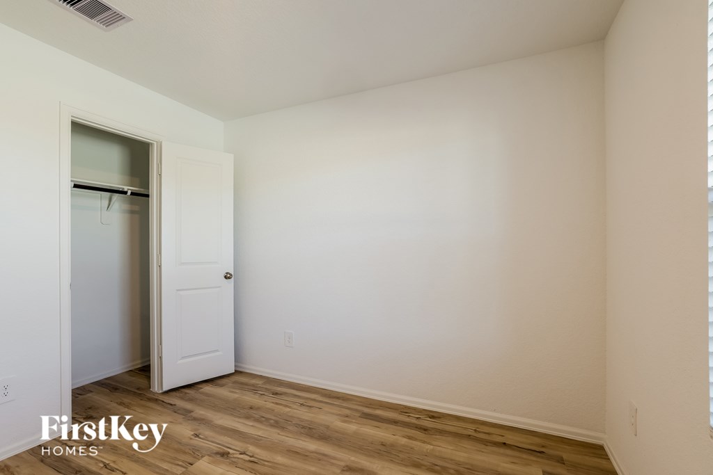 A room with a white door and a wooden floor.
