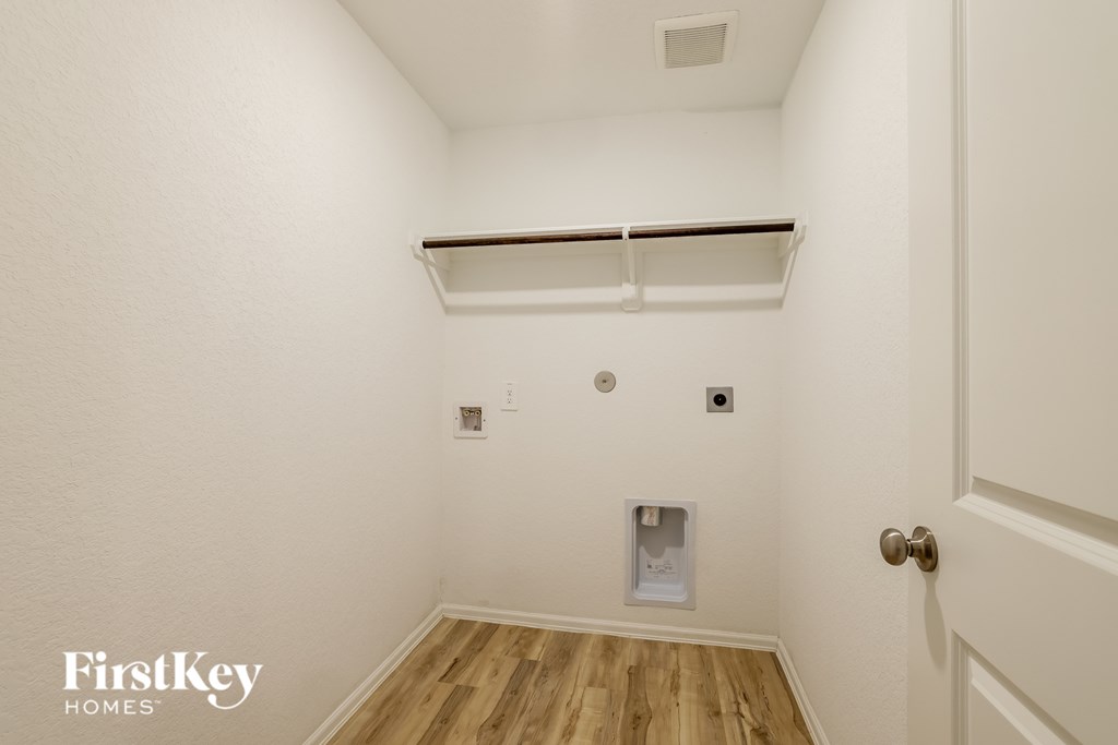 A small room with a door and a shelf above it.