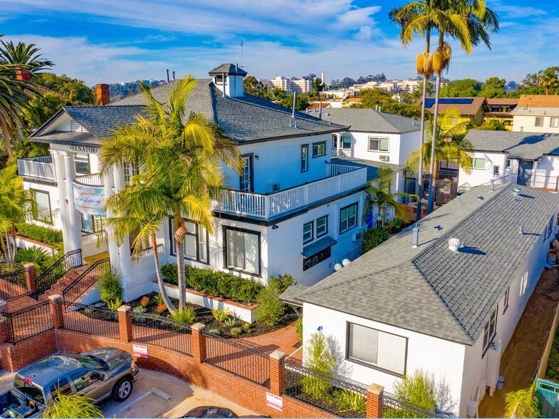 an aerial view of a blue and white house with palm trees
