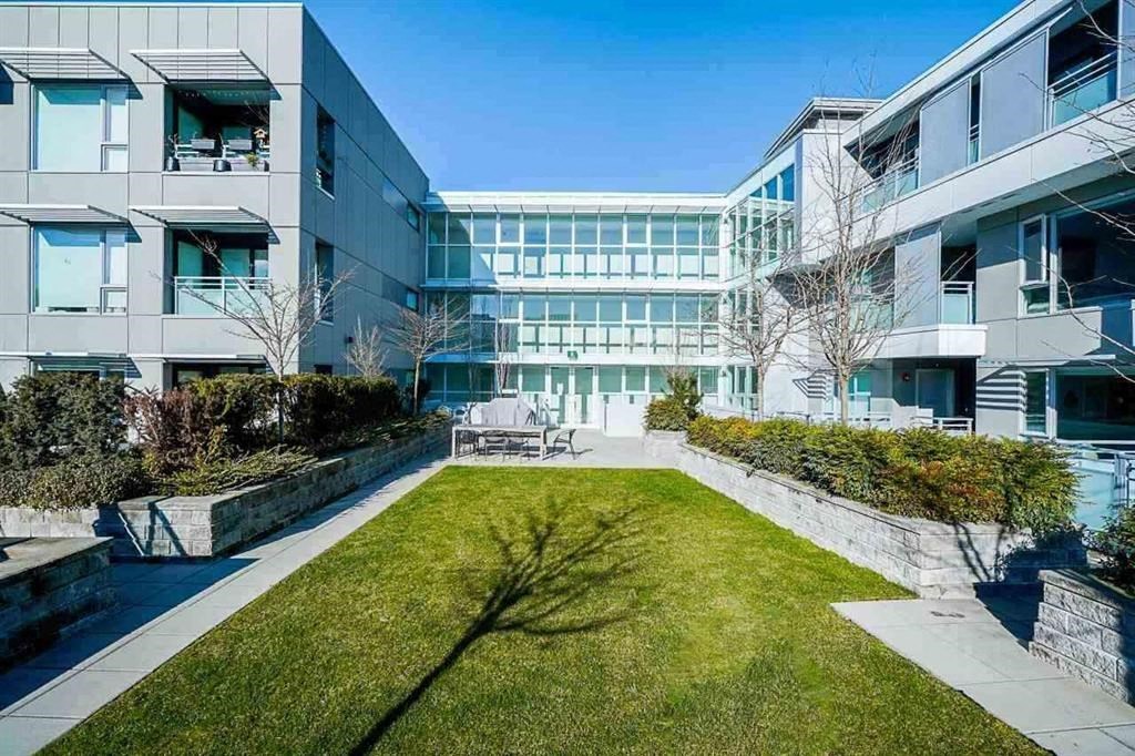 a courtyard with a lawn in front of an apartment building