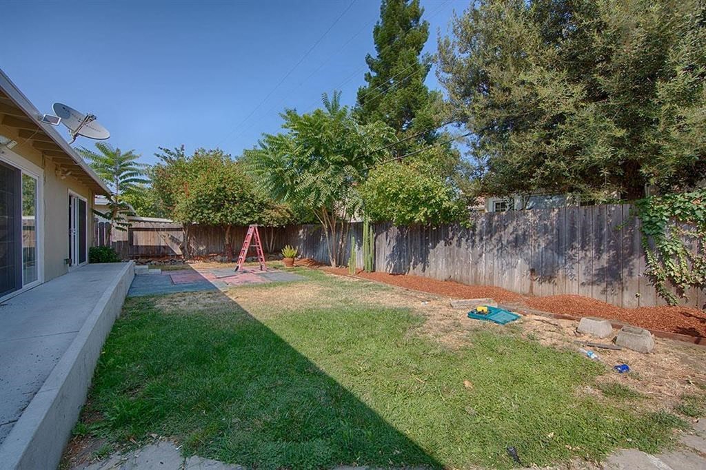 a backyard with a fence and a yard with a swing set