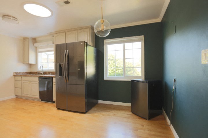 a kitchen with a stainless steel refrigerator and a window