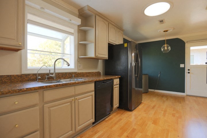 a kitchen with a sink and a black refrigerator