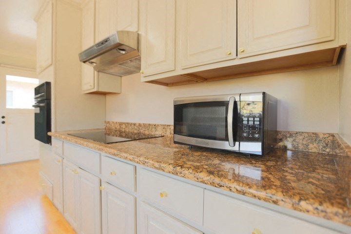 a kitchen with a microwave and white cabinets