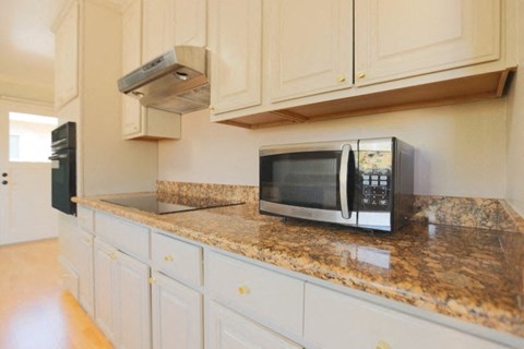 a kitchen with a microwave and white cabinets