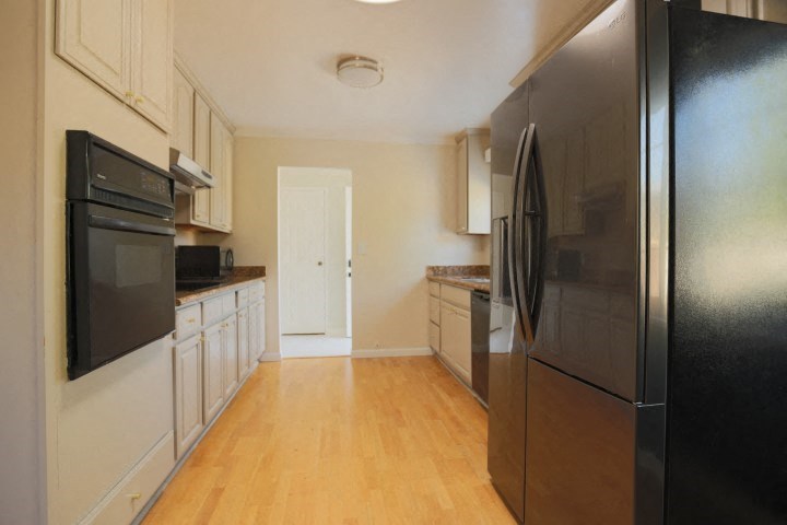 a kitchen with stainless steel appliances and a wooden floor