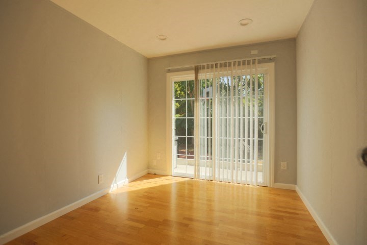 a living room with a wooden floor and a glass door