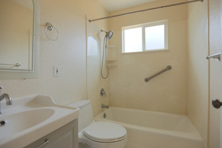 a bathroom with a toilet and a sink and a bath tub